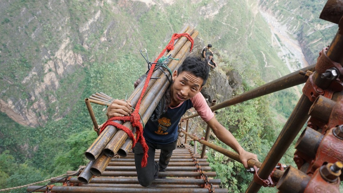 A man climbs up the mountain to Atule'er village in Sichuan province, China.