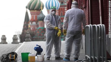 People wearing protective equipment disinfect the Red Square in Moscow.