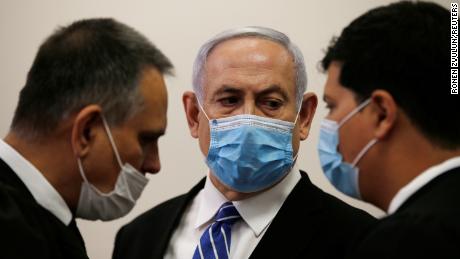 Prime Minister Benjamin Netanyahu stood with lawyers in the Jerusalem District Court on Sunday.
