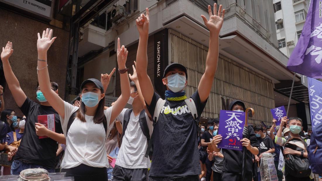 Protesters gesture with five fingers, signifying the &quot;Five demands - not one less&quot; as they march along a downtown street during a pro-democracy protest against Beijing's national security legislation in Hong Kong, Sunday, May 24, 2020. Hong Kong's pro-democracy camp has sharply criticised China's move to enact national security legislation in the semi-autonomous territory. They say it goes against the &quot;one country, two systems&quot; framework that promises the city freedoms not found on the mainland.