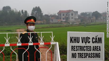 Vietnam People's Army officers stand next to a warning sign about the lockout of the Son Loi commune in Vinh Phuc province on February 20.