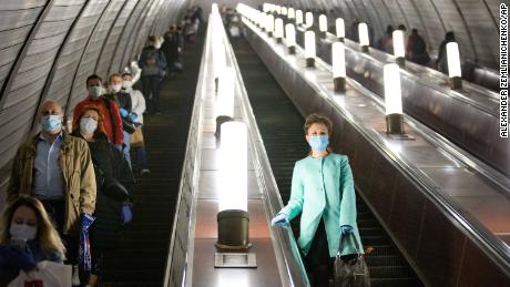 People wear masks and gloves on the subway escalator in Moscow on Tuesday.