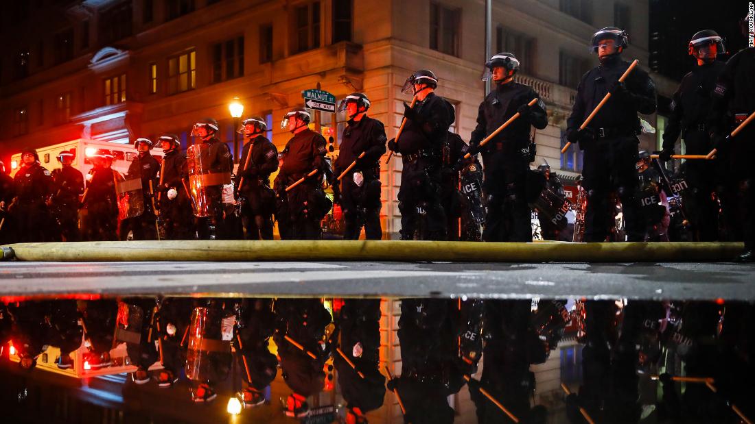 Philadelphia police are reflected as they stand guard during a protest over the death of George Floyd on Saturday, May 30, 2020.