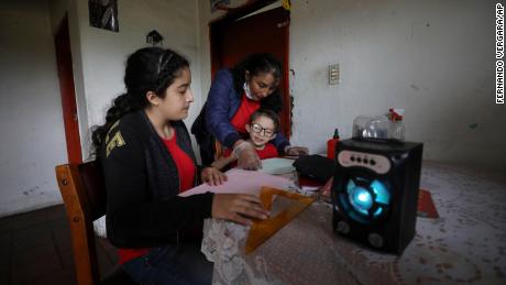 A family listens to radio lessons for an hour from their home in Funza, Colombia, where they have no internet connection.