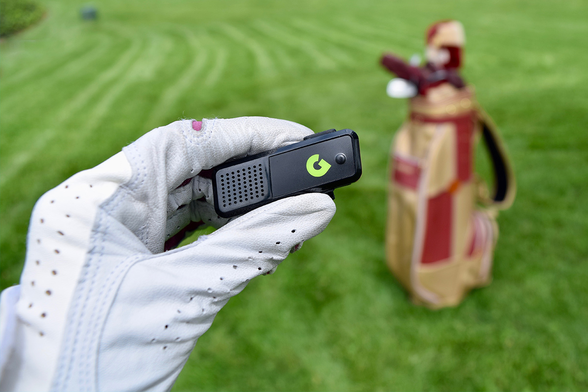 Someone who wears golf gloves, holds a range finder. 