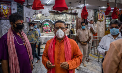 Indian Hindu priests and devotees walk inside Hunuman Mandir, on June 8, in Delhi.