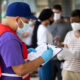 Community outreach specialist Rogelio Bucio collects patient information as they wait in line at a walk up Covid-19 testing site on June 27, in Dallas, Texas.