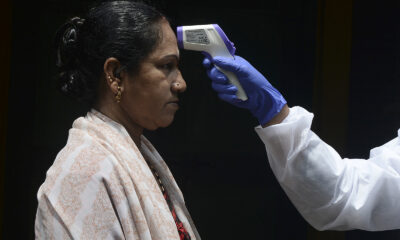 A doctor checks a woman's temperature at her residence during a government-imposed lockdown in Chennai, India, on June 29.