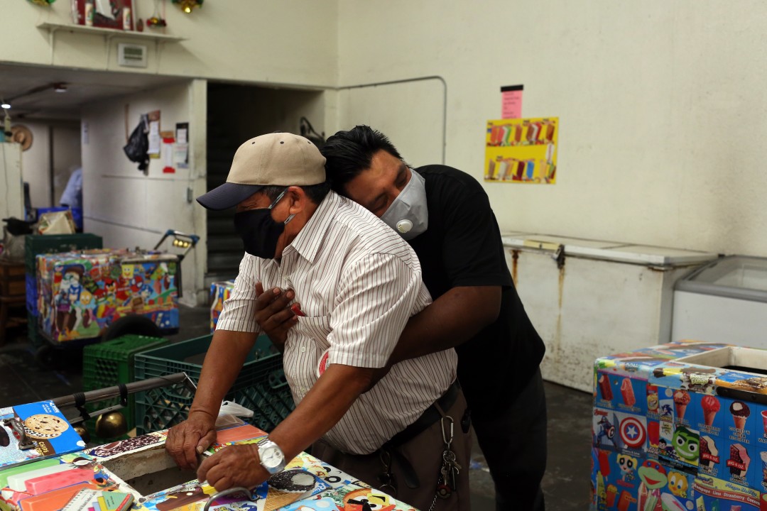 Oscar Samano, right, hugged Rios inside Barahona Ice Cream.