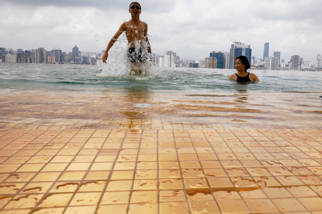 A boy jumps into the water next to his mother in a gold-plated infinity pool in the luxury hotel of the newly opened Dolce Hanoi Golden Lake in Hanoi