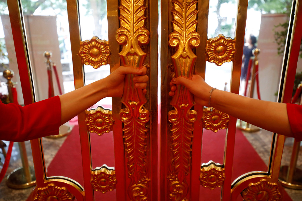 FILE PHOTO: Staff members open the doors of the newly inaugurated Dolce Hanoi Golden Lake luxury hotel, which features a gold-plated exterior and interior, after the government loosened national lockdown following the global outbreak of the corona virus