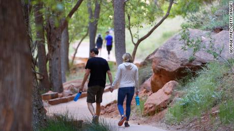 Pedestrians walk along footpaths in Zion National Park, Utah, which has been closed due to a pandemic.
