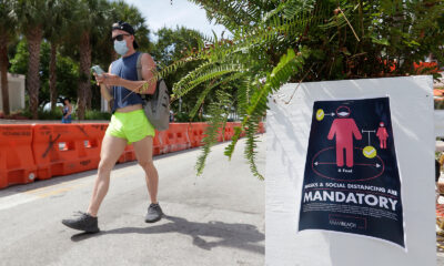 A pedestrian walks down Ocean Drive in Miami July 4.