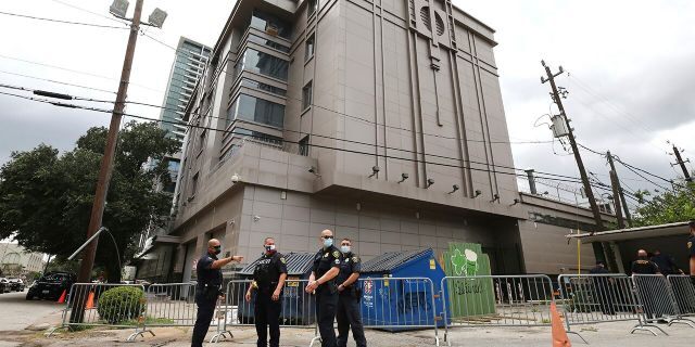 Police officers install barricades outside the Consulate General of China Friday, July 24, 2020, in Houston. Workers at China's consulate loaded up moving trucks Friday ahead of an afternoon deadline to shut down the facility, as ordered by the Trump administration. (Godofredo Vasquez/Houston Chronicle via AP)