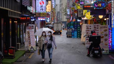 Two women wear face masks in Seoul. Countries in which covering one&#39;s face is a social norm have generally fared better during the pandemic.