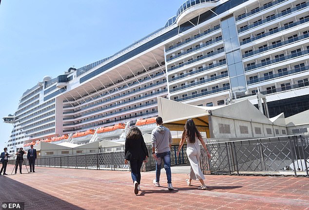 The Italian government gave its approval for cruises to depart from the country's ports earlier this month, limited to 70 per cent capacity. Pictured: People on their way to board the MSC Grandiosa cruise ship at a port in Genoa