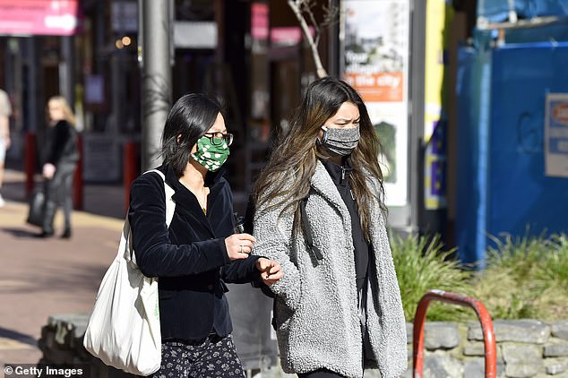 Two women wear face masks as they walk in Wellington, New Zealand, on Saturday (pictured)
