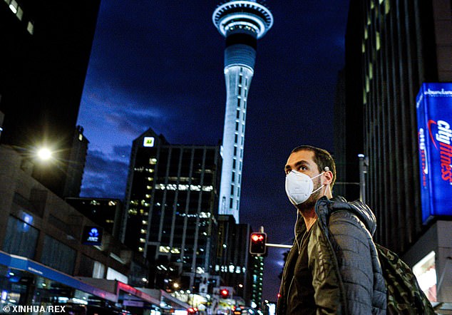 A man wearing a face mask is seen in downtown Auckland, New Zealand on Wednesday (pictured)