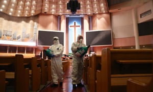 Disinfection workers wearing protective clothing spray anti-septic solution in an Yoido Full Gospel Church in Seoul.