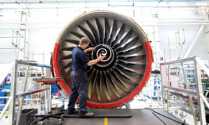 An employee fits the nose cone to a Trent 700 aircraft engine on the production line at the Rolls-Royce factory in Derby.