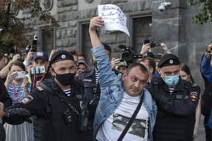 Police officers detain a protester as he comes to support Russian opposition leader Alexei Navalny in front of the building of the Federal Security Service on 20 August