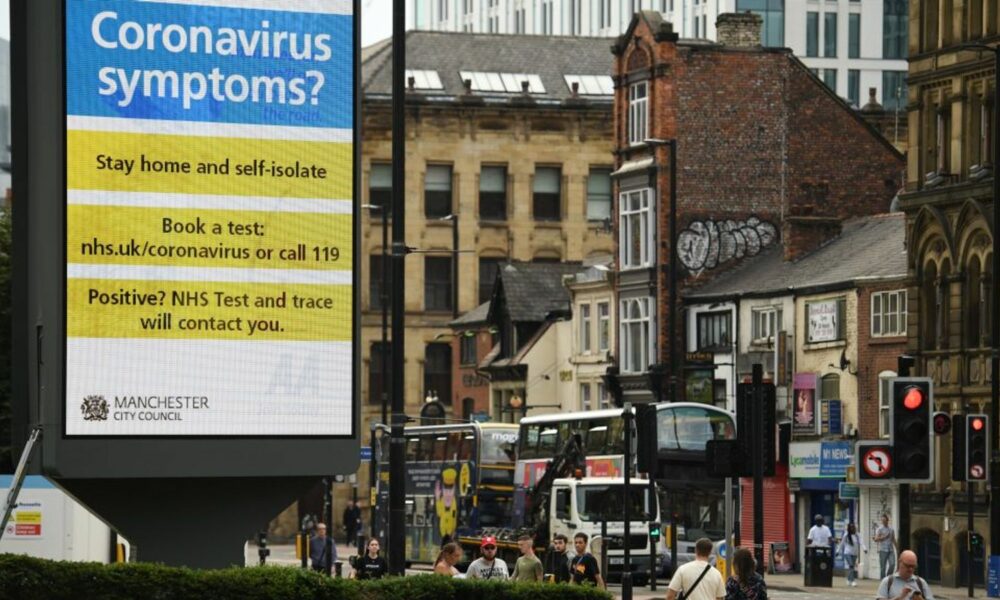 A large electronic billboard displays a message listing the actions that must be taken if you have symptoms of COVID-19, the disease caused by the novel coronavirus, in Manchester, northwest England, on July 31, 2020. - Britain today "put the brakes on" easing lockdown measures and imposed new rules on millions of households in northern England, following concerns over a spike in coronavirus infections. (Photo by Oli SCARFF / AFP) (Photo by OLI SCARFF/AFP via Getty Images)