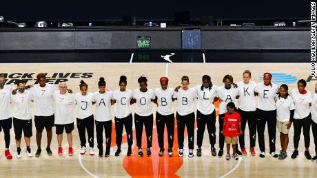 After the WNBA announcement of the postponed games for the evening, the Washington Mystics each wear white T-shirts with seven bullets on the back protesting the shooting of Jacob Blake.