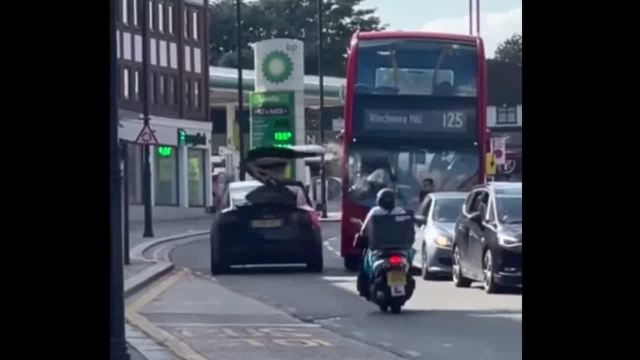 Tesla.  The video shows a Model X with an open door crashing into a bus
