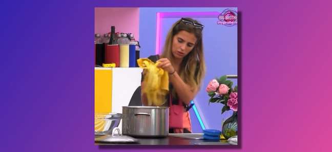 The contestant uses a dirty rag to take the pasta from the sink and put it into the spaghetti pot.